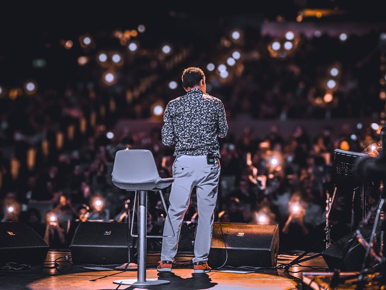 back-view-of-speaker-on-stage-with-audience-lights-31129059